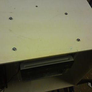 Screwing the drive cage to the roof of the cube